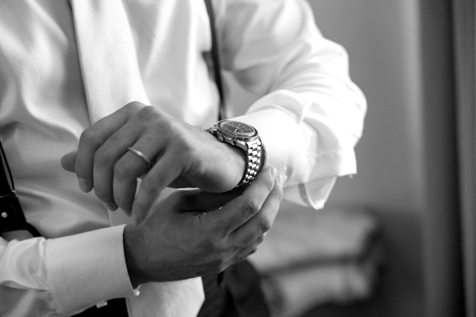 Dettaglio in bianco e nero delle mani e dell'orologio dello sposo